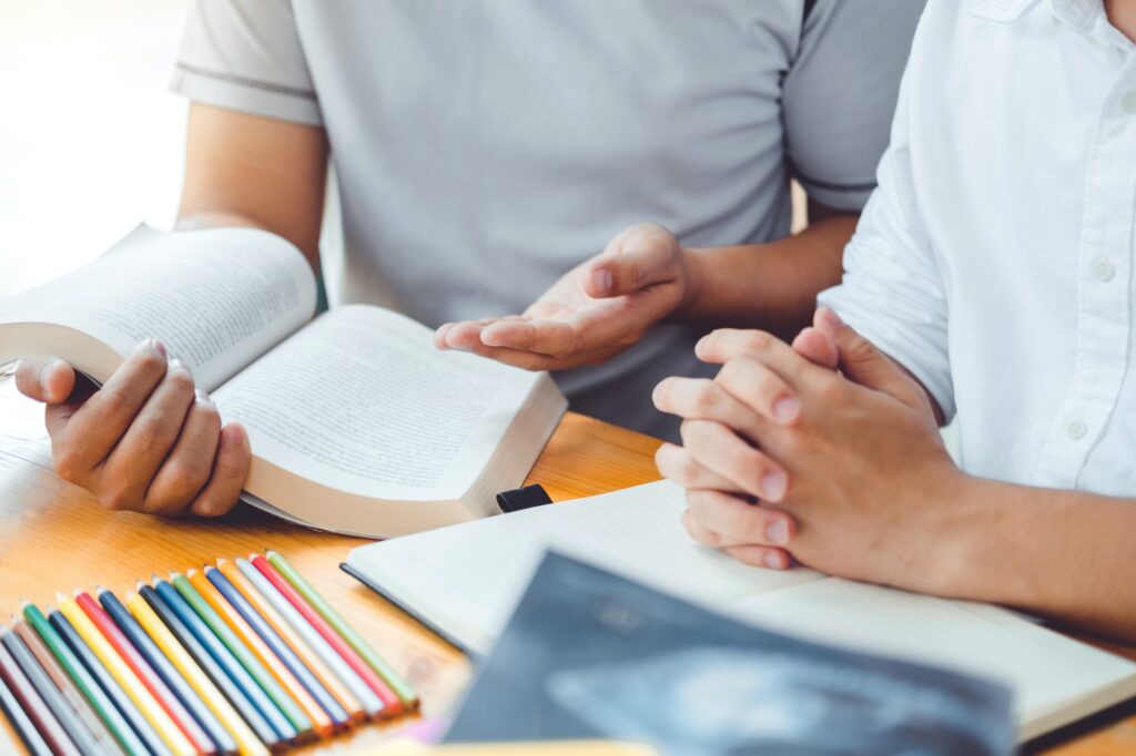 High school or college students studying and reading together in library